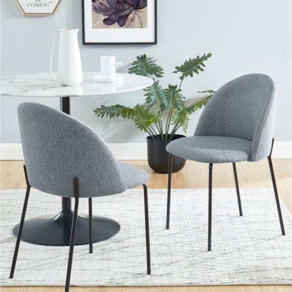 Devant vous se trouve une chaise moderne avec un revêtement en tissu de couleur grise. Elle a une forme accueillante avec un dossier arrondi qui s'incline légèrement vers l'arrière pour épouser le dos. Le dossier et l'assise forment une seule pièce courbée pour un effet épuré et confortable. Les quatre pieds sont fins, en métal laqué noir, ce qui crée un contraste élégant avec le tissu gris. Leur disposition offre une stabilité robuste et simple. Le style général évoque un design minimaliste et chic, adapté à divers environnements contemporains.