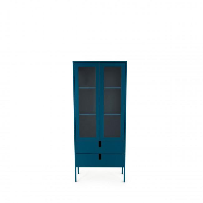Ce meuble est un vaisselier de couleur bleu canard, ce qui évoquerait une nuance de bleu profond avec des reflets légèrement verts. Il est en bois. La partie supérieure est constituée de deux portes vitrées qui permettraient de voir à l'intérieur, où se trouvent probablement des étagères pour ranger la vaisselle ou des objets décoratifs. Ces deux portes sont compartimentées en trois zones vitrées chacune, créant un aspect esthétique de fenêtres. La partie inférieure comporte deux tiroirs alignés horizontalement qui offrent un espace de rangement supplémentaire et sont dotés de poignées discrètes et modernes. Le vaisselier repose sur quatre pieds fins et élancés en métal, qui le surélèvent et lui confèrent une touche de légèreté et de design contemporain. L'arrière-plan est neutre et blanc, mettant ainsi en avant le meuble lui-même.